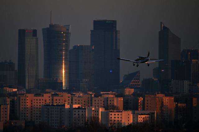 A Piper Cherokee 180D airplane lands at Warsaw Babice Airport with Warsaw's skyscrapers in the background, as seen from the village of Klaudyn, Masovian Voivodeship on November 6, 2025. (Photo by Sergei GAPON / AFP)