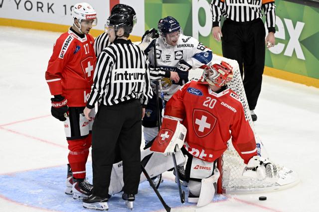 Ken Jaeger (L) of Switzerland talks with referees while Sakari Manninen of Finland reacts  with Swiss goalkeeper Reto Berra during the Euro Hockey Tour EHT Karjala Cup ice hockey match between Switzerland and Finland in Tampere, Finland, on November 6, 2025. (Photo by Emmi Korhonen / Lehtikuva / AFP) / Finland OUT