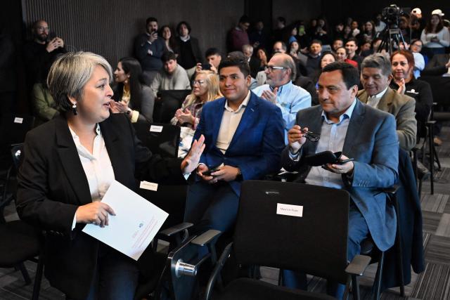 Chile's presidential candidate Jeannette Jara (L), of the Unidad por Chile coalition, waves during a meeting with Cooperatives of Chile, a national association founded in 2018 that represents and advocates for cooperative organizations across the country, in Santiago, on November 6, 2025. Chile will hold the presidential election on November 16. (Photo by RODRIGO ARANGUA / AFP)