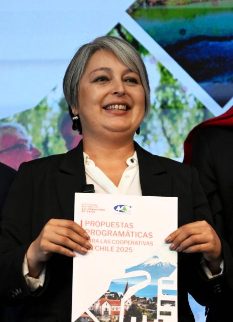 Chile's presidential candidate Jeannette Jara (L), of the Unidad por Chile coalition, holds a document during a meeting with Cooperatives of Chile, a national association founded in 2018 that represents and advocates for cooperative organizations across the country, in Santiago, on November 6, 2025. Chile will hold the presidential election on November 16. (Photo by RODRIGO ARANGUA / AFP)