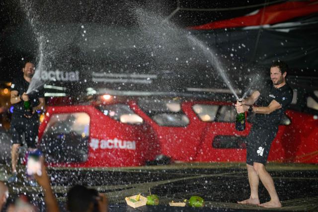 "Actual" Ultim multihull French skippers Julien Villion (R) and Anthony Marchand spray champagne after placing third in the Ultim class of 17th edition of the Transat Cafe L'Or, off the shores of Fort-de-France, in the French overseas island of Martinique on November 6, 2025. Four open classes take part in the race: IMOCA, Ocean Fifty, ULTIM and Class40. The Transat Cafe L'Or is a duo sailing race from Le Havre to Fort-de-France, in the French Caribbean island of Martinique. (Photo by Loic VENANCE / AFP)