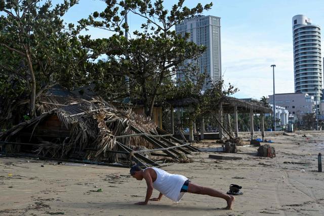 A man exercises on the debris-strewn beach in Quy Nhon in Gia Lai province, central Vietnam on November 7, 2025, after typhoon Kalmaegi hit the area. Typhoon Kalmaegi swept across Vietnam early on November 7, weakening into a tropical storm after claiming at least 188 lives in the Philippines. (Photo by Nhac NGUYEN / AFP)