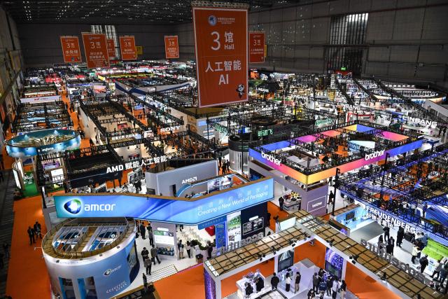 Visitors attend the 8th China International Import Expo (CIIE) in Shanghai on November 7, 2025. (Photo by Hector RETAMAL / AFP)