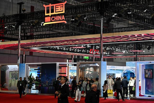 Visitors look  in the China pavillion during the 8th China International Import Expo (CIIE) in Shanghai on November 7, 2025. (Photo by Hector RETAMAL / AFP)
