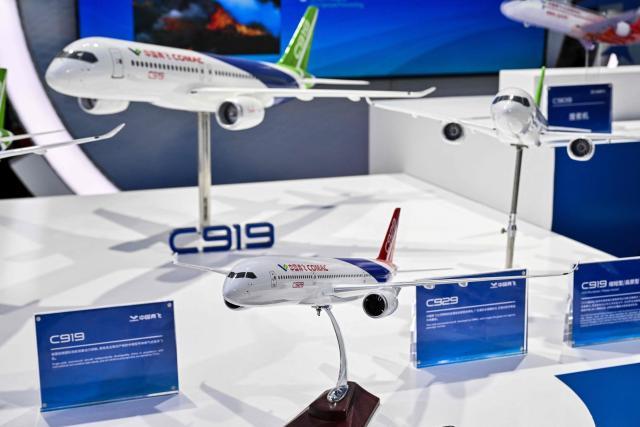 Models of C19 and C929 aircraft are displayed in the Commercial Aircraft Corporation of China booth during the 8th International Import Expo (CIIE) in Shanghai on November 7, 2025. (Photo by Hector RETAMAL / AFP)