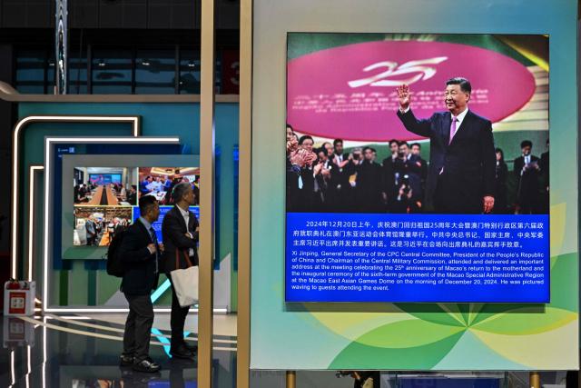 A picture of China's President Xi Jinping is displayed at China's pavillion during the 8th International Import Expo (CIIE) in Shanghai on November 7, 2025. (Photo by Hector RETAMAL / AFP)