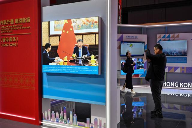 A picture of China's President Xi Jinping is displayed at China's pavillion during the 8th International Import Expo (CIIE) in Shanghai on November 7, 2025. (Photo by Hector RETAMAL / AFP)
