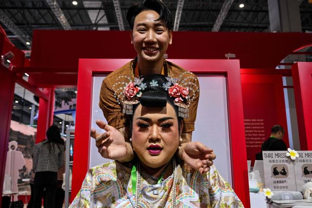 A visitor receives a massage at Thailand's pavillion during the 8th International Import Expo (CIIE) in Shanghai on November 7, 2025. (Photo by Hector RETAMAL / AFP)