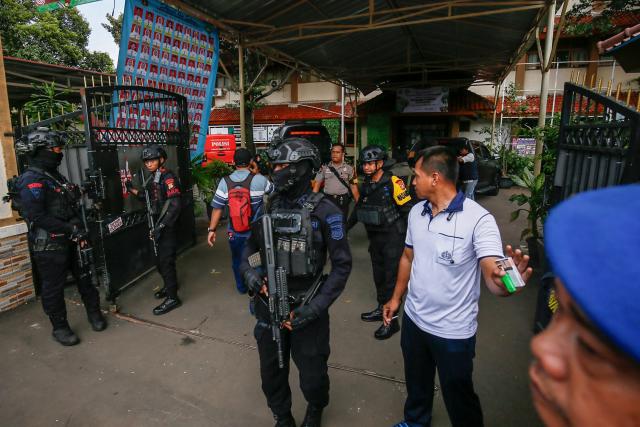 Bomb squad officers stand guard at the entrance of a school in Jakarta on November 7, 2025. A blast injured dozens of people near a school in Indonesia's capital on November 7, a senior police official said without disclosing the cause of the explosion. (Photo by CANDRA / AFP)
