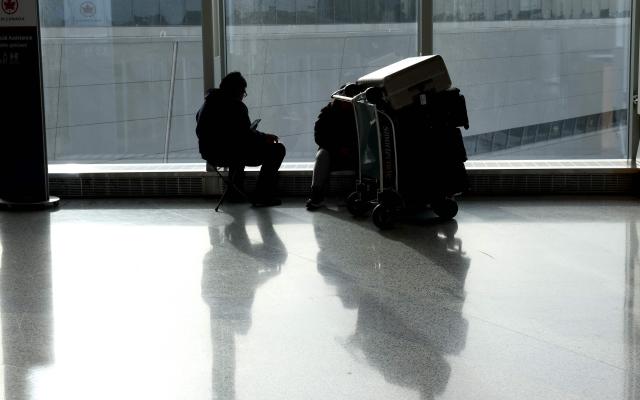 A traveler waits with his luggage at Newark Liberty International Airport in Newark, New Jersey, on November 7, 2025. Hundreds of flights were canceled across the United States on Friday after the Trump administration ordered reductions to ease strain on air traffic controllers who are working without pay amid congressional paralysis on funding the US budget. Forty airports were due to slow down, including the giant hubs in Atlanta, Newark, Denver, Chicago, Houston and Los Angeles. (Photo by TIMOTHY A. CLARY / AFP)
