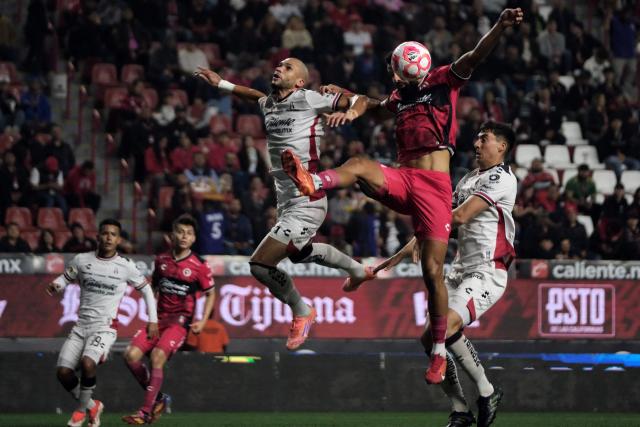 Atlas' Brazilian defender #05 Doria and Tijuana's Spanish forward #21 Mourad El Ghezouani fight for the ball during the Liga MX Apertura football match between Tijuana and Atlas at Caliente Stadium in Tijuana, Mexico on November 7, 2025. (Photo by Guillermo Arias / AFP)