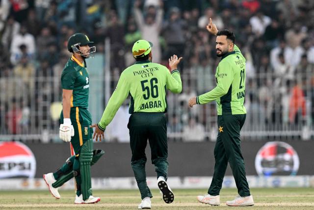 Pakistan's Mohammad Nawaz (R) celebrates with Babar Azam (C) after taking the wicket of South Africa's Bjorn Fortuin during the third and final one-day international (ODI) cricket match between Pakistan and South Africa at the Iqbal Stadium in Faisalabad on November 8, 2025. (Photo by Aamir QURESHI / AFP)
