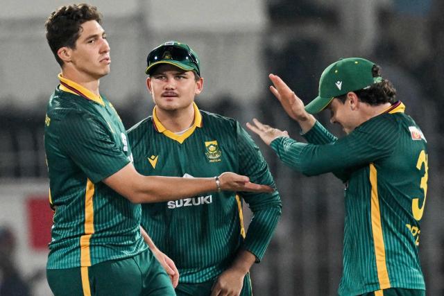 South Africa's Nandre Burger (L) celebrates with captain Matthew Breetzke (R) after taking the wicket of Pakistan's Fakhar Zaman during the third and final one-day international (ODI) cricket match between Pakistan and South Africa at the Iqbal Stadium in Faisalabad on November 8, 2025. (Photo by Aamir QURESHI / AFP)