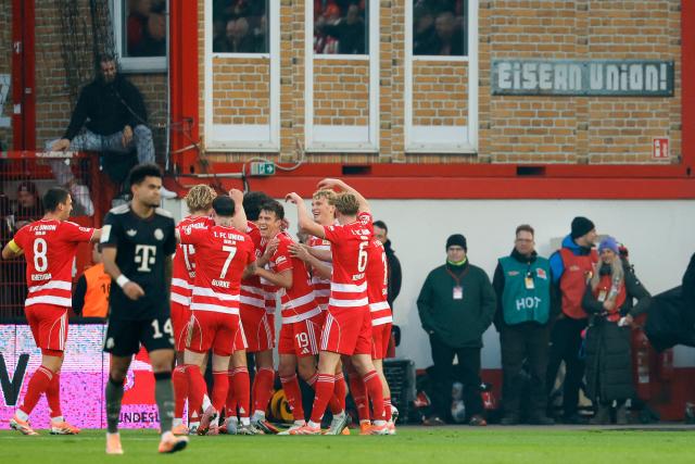 Union Berlin's players celebrate the opening goal by Dutch defender #05 Danilho Doekhi during the German first division Bundesliga football match between 1 FC Union Berlin and FC Bayern Munich in Berlin on November 8, 2025. (Photo by Odd ANDERSEN / AFP) / DFL REGULATIONS PROHIBIT ANY USE OF PHOTOGRAPHS AS IMAGE SEQUENCES AND/OR QUASI-VIDEO