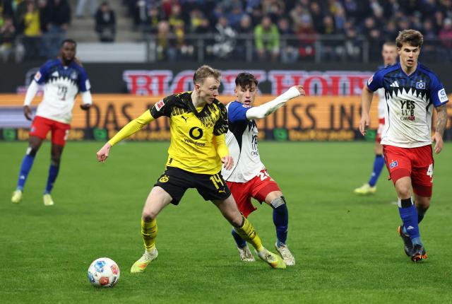 Dortmund's German forward #14 Maximilian Beier (L) and Hamburg's French forward #14 Rayan Philippe vie for the ball during the German first division Bundesliga football match between Hamburger SV and Borussia Dortmund in Hamburg, northern Germany on November 8, 2025. (Photo by Ibrahim OT / AFP) / DFL REGULATIONS PROHIBIT ANY USE OF PHOTOGRAPHS AS IMAGE SEQUENCES AND/OR QUASI-VIDEO