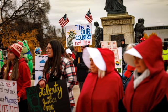 Participants dressed in long red robes and white bonnet-style headpieces, resembling characters from The Handmaid’s Tale, take part in the Handmaids' National Day of Action outside the Minnesota State Capitol in Saint Paul, Minnesota, on November 8, 2025. (Photo by Kerem YUCEL / AFP)