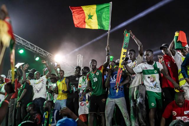 A supporter of Senegal’s Prime Minister Ousmane Sonko waves a Senegal flag during a rally in Dakar, on November 8, 2025. (Photo by PATRICK MEINHARDT / AFP)