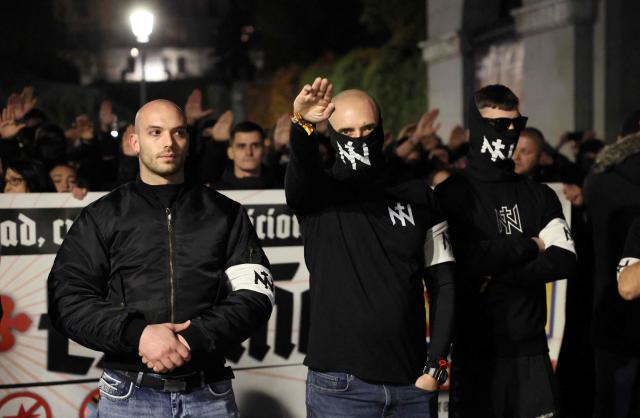 CORRECTION / Members of Spanish neonazi group Nucleo Nacional give a Nazi salute during a demonstration called to protest 'against the corrupt politicians' in front of the Spanish Congress in Madrid, on November 11, 2025. The police charged and fired tear gas to disperse the demonstration and detained at least three protestors of the group. The Nucleo Nacional (National Core) movement, investigated for hate incitement, was born in the aftermath of the protests in front of the Spanish Socialist Party (PSOE) headquarters in Madrid against the amnesty granted to Catalan independence leaders in 2023. (Photo by Thomas COEX / AFP) / The erroneous mention[s] appearing in the metadata of this photo by Thomas COEX has been modified in AFP systems in the following manner: [on November 8, 2025] instead of [on November 11, 2025]. Please immediately remove the erroneous mention[s] from all your online services and delete it (them) from your servers. If you have been authorized by AFP to distribute it (them) to third parties, please ensure that the same actions are carried out by them. Failure to promptly comply with these instructions will entail liability on your part for any continued or post notification usage. Therefore we thank you very much for all your attention and prompt action. We are sorry for the inconvenience this notification may cause and remain at your disposal for any further information you may require.