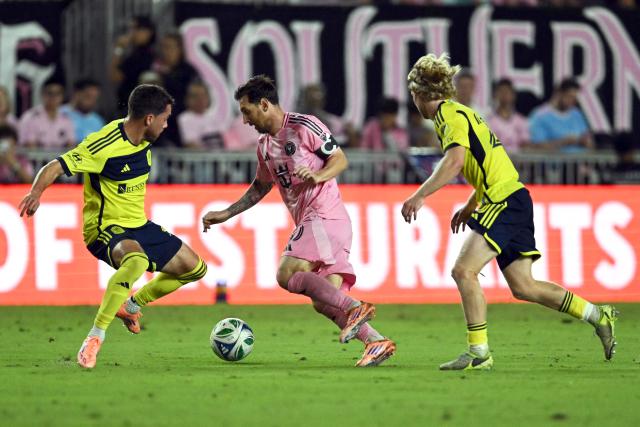 Inter Miami's Argentine forward #10 Lionel Messi (C) controls the ball between Nashville's Norwegian midfielder #20 Edvard Tagseth (R) and Nashville's US defender #02 Daniel Lovitz during the Major League Soccer (MLS) playoff football match between Inter Miami and Nashville SC at Chase Stadium in Fort Lauderdale, Florida on November 8, 2025. (Photo by Chandan Khanna / AFP)