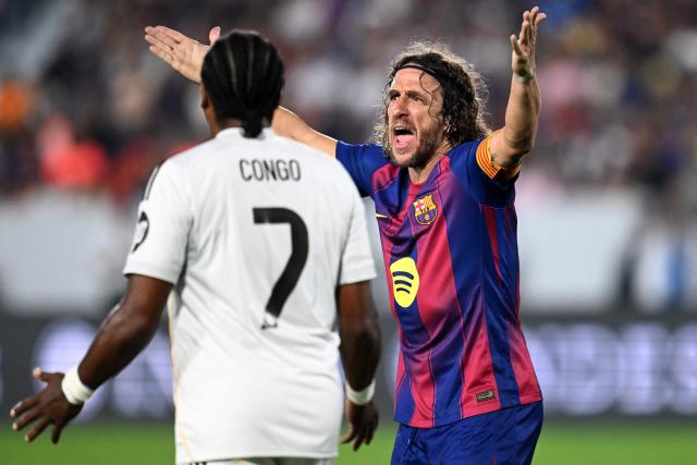 Barcelona's Carles Puyol argues next to Real Madrid's Edwin Congo during the exhibition friendly football match between Spain's Barcelona Legends and Real Madrid Legends at the Jorge "El Magico" Gonzalez Stadium in San Salvador on November 8, 2025. (Photo by Marvin RECINOS / AFP)