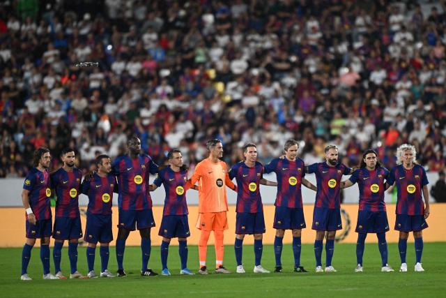 Barcelona Legends players take part in a minute of silence for the death of former Salvadoran player Jaime Rodriguez ahead of the exhibition friendly football match between Spain's Barcelona Legends and Real Madrid Legends at the Jorge "El Magico" Gonzalez Stadium in San Salvador on November 8, 2025. (Photo by Marvin RECINOS / AFP)
