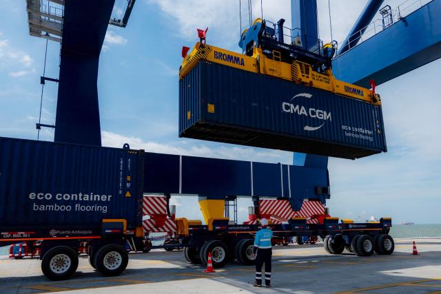 A container crane lifts a container at port installations of Puerto Antioquia in the Gulf of Uraba, Antioquia department, Colombia on November 8, 2025. France's Foreign Affairs Minister Jean-Noel Barrot travelled to the troubled Gulf of Uraba to visit a huge port under construction, which is one of the largest French private investment projects in Colombia, according to the diplomatic delegation. (Photo by Luis ACOSTA / AFP)