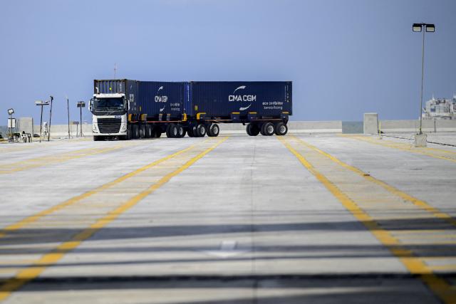 A container truck is pictured at the port installations of Puerto Antioquia in the Gulf of Uraba, Antioquia department, Colombia on November 8, 2025. France's Foreign Affairs Minister Jean-Noel Barrot travelled to the troubled Gulf of Uraba to visit a huge port under construction, which is one of the largest French private investment projects in Colombia, according to the diplomatic delegation. (Photo by Luis ACOSTA / AFP)