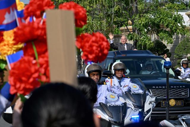 Cambodia's King Norodom Sihamoni (R) greets people from his car during a ceremony marking Cambodia's 72nd Independence Day celebrations at the Independence Monument in Phnom Penh on November 9, 2025. (Photo by TANG CHHIN Sothy / AFP)