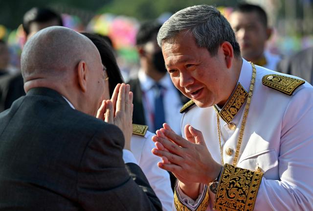 Cambodia's King Norodom Sihamoni (L) greets Prime Minister Hun Manet (R) during a ceremony marking Cambodia's 72nd Independence Day celebrations at the Independence Monument in Phnom Penh on November 9, 2025. (Photo by TANG CHHIN Sothy / AFP)