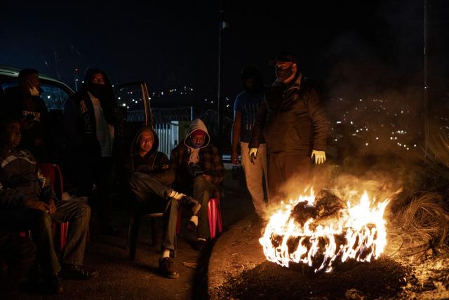 (FILES) Members of the Phoenix Community Policing Forum, a grassroots mobilisation group involving local residents sit around a tyre set ablaze while on a lookout in Durban, on July 20, 2021. The trial of Duduzile Zuma-Sambudla, daughter of South Africa's former president Jacob Zuma, accused of inciting 2021 riots that left more than 350 people dead, was set by the Durban High Court to start November 10, 2025.
Duduzile Zuma-Sambudla, 42, is among several people charged with inciting terrorism and public violence via posts on social media after Zuma was sent to prison in July 2021 for refusing to testify in corruption proceedings against him.
The explosion of rioting and looting that followed was the deadliest unrest in South Africa since the fall of the white-minority government in 1994. 
Zuma-Sambudla denies the charges and claims the case is politically motivated. (Photo by MARCO LONGARI / AFP)