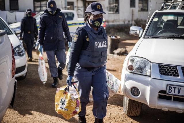 (FILES) South African police officers recover items at the Nguni Hostels in Vosloorus, on July 27, 2021 during a joint operation between the South Africa Police Service (SAPS) and the South Africa National Defence Forces (SANDF). The trial of Duduzile Zuma-Sambudla, daughter of South Africa's former president Jacob Zuma, accused of inciting 2021 riots that left more than 350 people dead, was set by the Durban High Court to start November 10, 2025.
Duduzile Zuma-Sambudla, 42, is among several people charged with inciting terrorism and public violence via posts on social media after Zuma was sent to prison in July 2021 for refusing to testify in corruption proceedings against him.
The explosion of rioting and looting that followed was the deadliest unrest in South Africa since the fall of the white-minority government in 1994. 
Zuma-Sambudla denies the charges and claims the case is politically motivated. (Photo by MARCO LONGARI / AFP)