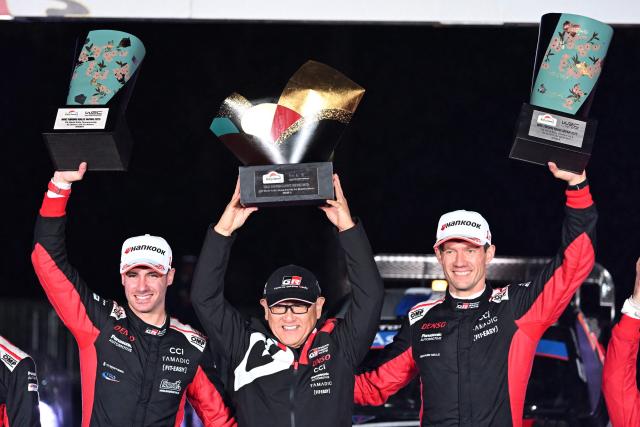 Sebastien Ogier (R) and his co-driver Vincent Landais (L) of France celebrate their victory with Toyota Gazoo Racing chairman Akio Toyoda (C) during the podium ceremony of the Rally Japan, the 13th round of the FIA World Rally Championships, in Toyota city, Aichi prefecture on November 9, 2025. (Photo by Toshifumi KITAMURA / AFP)