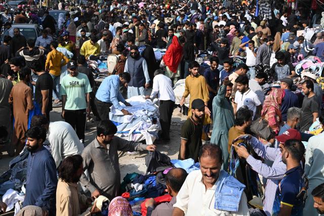 People buy winter wear at a market in Lahore on November 9, 2025. (Photo by Arif ALI / AFP)