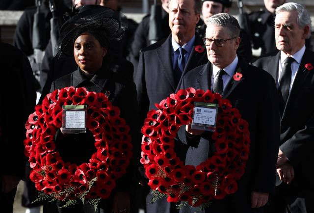 Britain's Prime Minister Keir Starmer (R) and Britain's main opposition Conservative Party leader Kemi Badenoch (L) hold their wreaths as former prime ministers David Cameron (back L) and Gordon Brown (back R) attend the Remembrance Sunday ceremony at the Cenotaph on Whitehall in central London on November 9, 2025. Remembrance Sunday is an annual commemoration held on the closest Sunday to Armistice Day, November 11, the anniversary of the end of the First World War and services across Commonwealth countries remember servicemen and women who have fallen in the line of duty since WWI. (Photo by HENRY NICHOLLS / POOL / AFP)