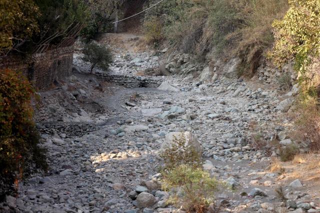 Rocks and pebbles cover the river bed of the dried-up Kan River, west of Tehran on November 9, 2025, as the Iran faces sever water shortages. Iran was laying plans on November 8, 2025, to cut off water supplies periodically to Tehran's 10-million-strong population as it battles its worst drought in many decades. (Photo by ATTA KENARE / AFP)