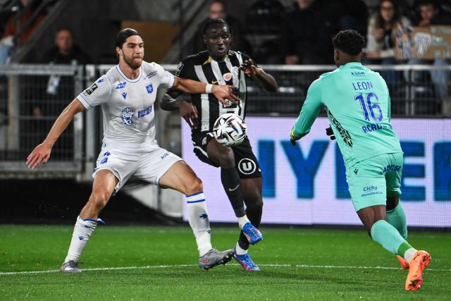 Angers' French forward #11 Sidiki Cherif (C) vies for the ball with Auxerre's Chilean defender #04 Francisco Sierralta (L) and Auxerre's French Guianese goalkeeper #16 Donovan Leon during the French L1 football match between SCO Angers and AJ Auxerre at the Stade Raymond-Kopa, in Angers, western France, on November 9, 2025. (Photo by JEAN-FRANCOIS MONIER / AFP)