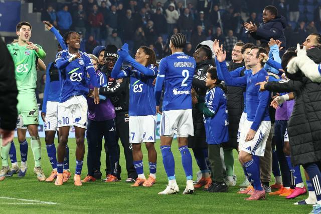 Strasbourg’s players celebrate after their victory at the end of the French L1 football match between RC Strasbourg Alsace and Lille LOSC at the Stade de la Meinau in Strasbourg, eastern France, on November 9, 2025. (Photo by Frederick FLORIN / AFP)