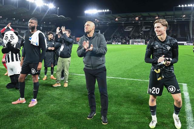 Angers' French head coach Alexandre Dujeux (C) applauds to fans following their 2-0 victory over AJ Auxerre at the end of the French L1 football match between SCO Angers and AJ Auxerre at the Stade Raymond-Kopa, in Angers, western France, on November 9, 2025. (Photo by JEAN-FRANCOIS MONIER / AFP)