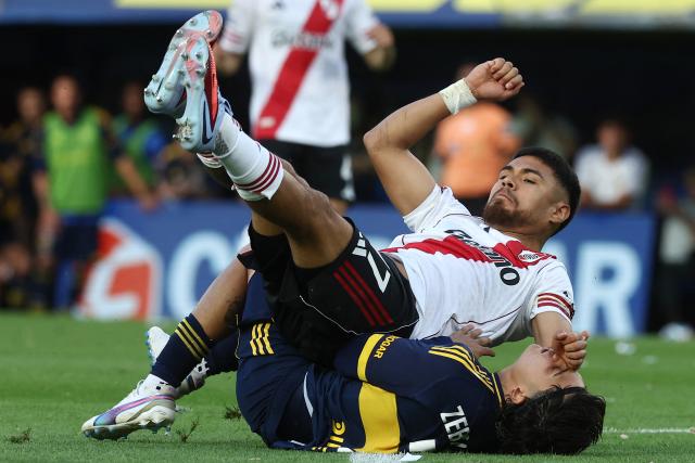 River Plate's Chilean defender #17 Paulo Diaz and Boca Juniors' Chilean midfielder #08 Carlos Palacios crash as they fight for the ball during the Argentine Professional Football League 2025 Clausura Tournament match between Boca Juniors and River Plate at the La Bombonera Stadium in Buenos Aires on November 9, 2025. (Photo by ALEJANDRO PAGNI / AFP)