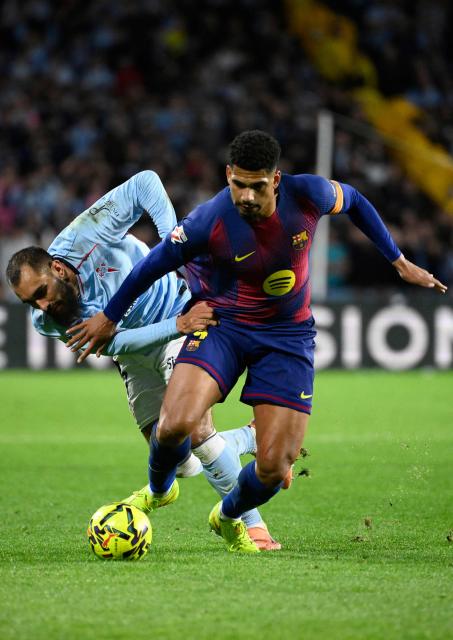 Celta Vigo's Spanish forward #07 Borja Iglesias (L) and Barcelona's Uruguayan defender #04 Ronald Federico Araujo da Silva fight for the ball during the Spanish league football match between RC Celta de Vigo and FC Barcelona at Balaidos Stadium in Vigo on November 9, 2025. (Photo by Miguel RIOPA / AFP)