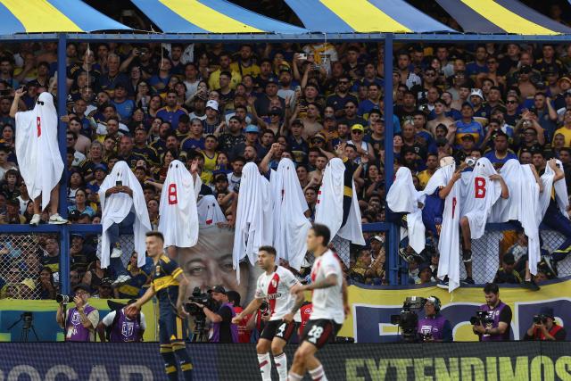Boca Juniors fans dressed as phantoms with the letter “B”—in allusion to the relegation of Argentina's River Plate team—cheer for their team during the Argentine Professional Football League 2025 Clausura Tournament match between Boca Juniors and River Plate at La Bombonera stadium in Buenos Aires on November 9, 2025. (Photo by ALEJANDRO PAGNI / AFP)