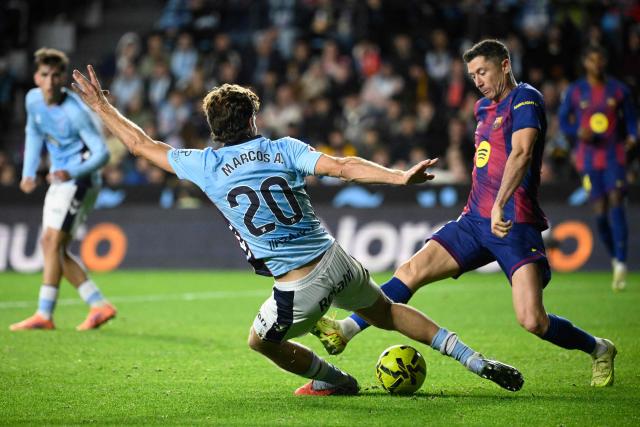 Celta Vigo's Spanish defender #20 Marcos Alonso Mendoza and Barcelona's Polish forward #09 Robert Lewandowski vie for the ball during the Spanish league football match between RC Celta de Vigo and FC Barcelona at Balaidos Stadium in Vigo on November 9, 2025. (Photo by Miguel RIOPA / AFP)