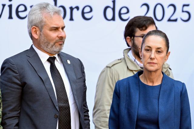 Mexico's President Claudia Sheinbaum (R) and Governor of Michoacan Alfredo Ramirez Bedolla (L) attend the presentation of the Michoacan Plan for Peace and Justice at the National Palace in Mexico City on November 9, 2025. Claudia Sheinbaum's government announced on November 9, 2024, that it would reinforce the military presence and official authorities in the western state of Michoacan following the murder of a mayor that has outraged the whole of Mexico. (Photo by Alfredo ESTRELLA / AFP)