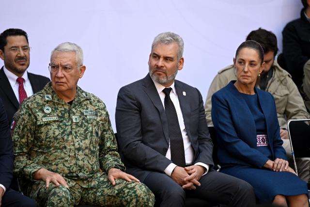 Mexico's Secretary of Defense Ricardo Trevilla Trejo (L), Governor of Michoacan Alfredo Ramirez Bedolla (C), and Mexico's President Claudia Sheinbaum (R) attend the presentation of the Michoacan Plan for Peace and Justice at the National Palace in Mexico City on November 9, 2025. Claudia Sheinbaum's government announced on November 9, 2024, that it would reinforce the military presence and official authorities in the western state of Michoacan following the murder of a mayor that has outraged the whole of Mexico. (Photo by Alfredo ESTRELLA / AFP)