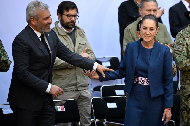 Mexico's President Claudia Sheinbaum (R) greets Governor of Michoacan Alfredo Ramirez Bedolla (L) during the presentation of the Michoacan Plan for Peace and Justice at the National Palace in Mexico City on November 9, 2025. Claudia Sheinbaum's government announced on November 9, 2024, that it would reinforce the military presence and official authorities in the western state of Michoacan following the murder of a mayor that has outraged the whole of Mexico. (Photo by Alfredo ESTRELLA / AFP)