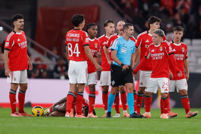 Benfica players speak with Portuguese referee Gustavo Correia after Casa Pia's second goal during the Portuguese league football match between SL Benfica and Casa Pia AC at Estadio da Luz in Lisbon on November 9, 2025. (Photo by FILIPE AMORIM / AFP)