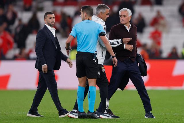 SL Benfica's Portuguese head coach #00 Jose Mourinho (R) speaks with Portuguese referee Gustavo Correia at the end of the Portuguese league football match between SL Benfica and Casa Pia AC at Estadio da Luz in Lisbon on November 9, 2025. (Photo by FILIPE AMORIM / AFP)