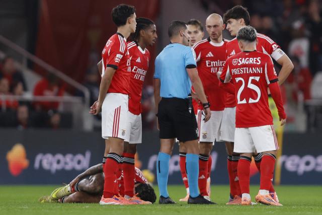 Benfica players speak with Portuguese referee Gustavo Correia after Casa Pia's second goal during the Portuguese league football match between SL Benfica and Casa Pia AC at Estadio da Luz in Lisbon on November 9, 2025. (Photo by FILIPE AMORIM / AFP)