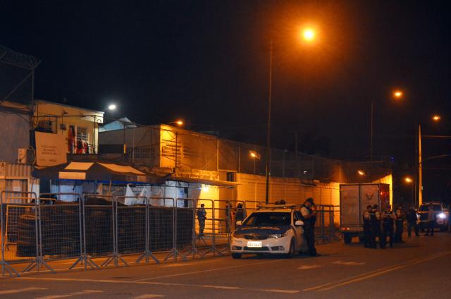 Police officers stand guard at the entrance of the prison after an armed riot that left four dead and dozens more injured in Machala, Ecuador on November 9, 2025. At least 27 prisoners were found dead from asphyxiation on Sunday afternoon in a prison in southwestern Ecuador, hours after police contained an armed riot that left four dead and dozens injured during the early hours of the morning. (Photo by Luis SUAREZ / AFP)