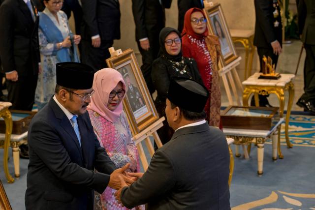 Indonesia's President Prabowo Subianto (R) congratulates the children of former president Suharto, Bambang Trihatmodjo (L) and Siti Hardijanti Rukmana (C), during a ceremony held to mark the National Heroes Day at the State Palace in Jakarta on November 10, 2025. Indonesia added former president Suharto to a list of national heroes during a ceremony on November 10, despite objections from activists and academics over the deceased military dictator's human rights record. (Photo by BAY ISMOYO / AFP)